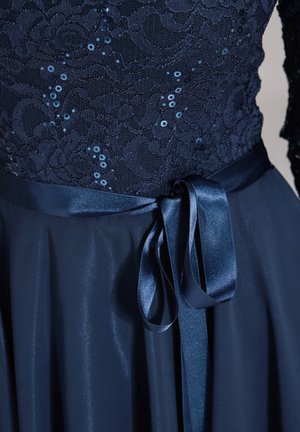Abito blu navy con un corpetto in pizzo decorato con paillettes, cintura in raso e gonna fluida e morbida. Tessuto morbido e design elegante.