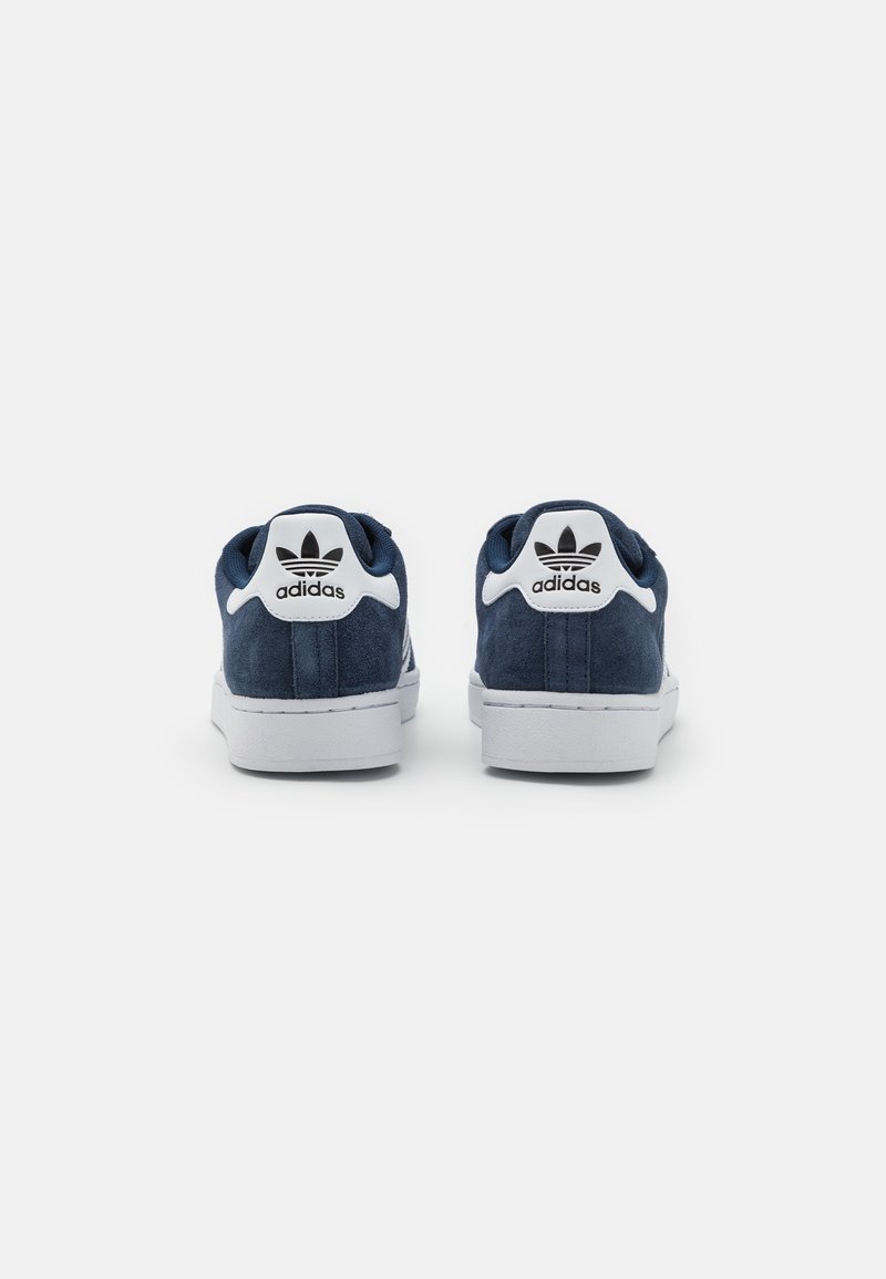 Marineblauwe suede sneakers met witte rubberen zolen, voorzien van een klassiek logo op de hiel en een gladde textuur, ontworpen voor casual draag.