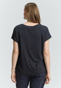 Zwarte top met korte mouwen, een wijde halslijn en een ontspannen pasvorm, gemaakt van een gladde, lichte stof. De achterkant is eenvoudig met minimale stiksels.