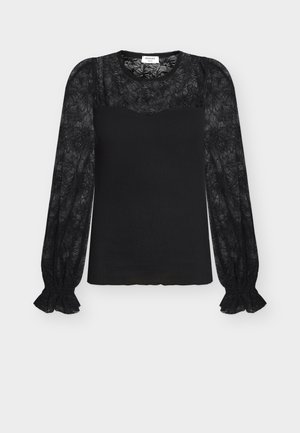 Haut noir à manches longues avec motif floral en dentelle sur les manches et le haut de la poitrine, tissu côtelé sur le torse, et poignets à volants.