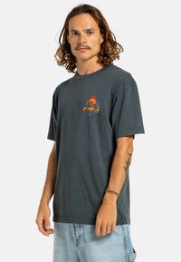 Dunkelgraues Baumwoll-T-Shirt für Herren mit einem Frontdruck in Rot, Blau und Orange, der einen Globus und Flammen darstellt. Es hat kurze Ärmel und einen runden Halsausschnitt.