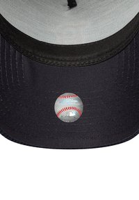Schwarze Baseballmütze mit einer glatten grauen Unterseite, versehen mit einem runden MLB-Hologramm-Aufkleber, der ein Baseball-Design zeigt.