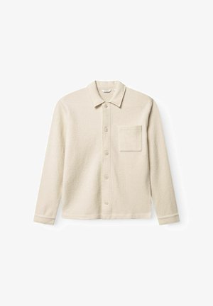 Oficialiai balta, tekstūruota marškinėlių striukė su apykakle, priekiniais mygtukais ir krūtine kišene. Ilgos rankovės su mygtukais. Kasdienis dizainas.