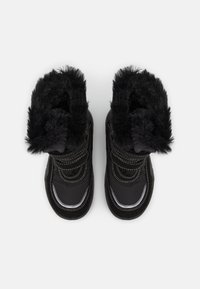 Svarta isolerade stövlar med imitationspäls, med kontrasterande sömmar, rund tå och en robust gummisula. Dekorationer inkluderar två justerbara remmar.