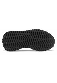 Musta kengänpohja siksak-kuviolla, jossa on kohokuvioitu brändäys. Materiaali näyttää kumipinnoitetulta, tarjoten pitoa ja kestävyyttä.