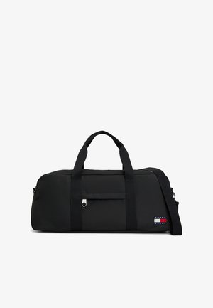 Czarna prostokątna torba sportowa z podwójnymi uchwytami, przednią kieszenią na zamek, odpinanym paskiem na ramię oraz naszywką z logo Tommy Jeans na boku.