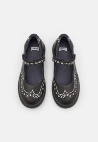 Czarne skórzane buty o zaokrąglonym nosku, z białym dekoracyjnym wzorem i centralnym paskiem. Wnętrze wyłożone niebieską tkaniną.