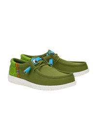 Grüne Canvas-Schuhe mit einer weißen gesprenkelten Sohle. Mit blauen Akzenten und einem verspielten Schildkrötenmuster an der Seite. Einfaches Schnürdesign.