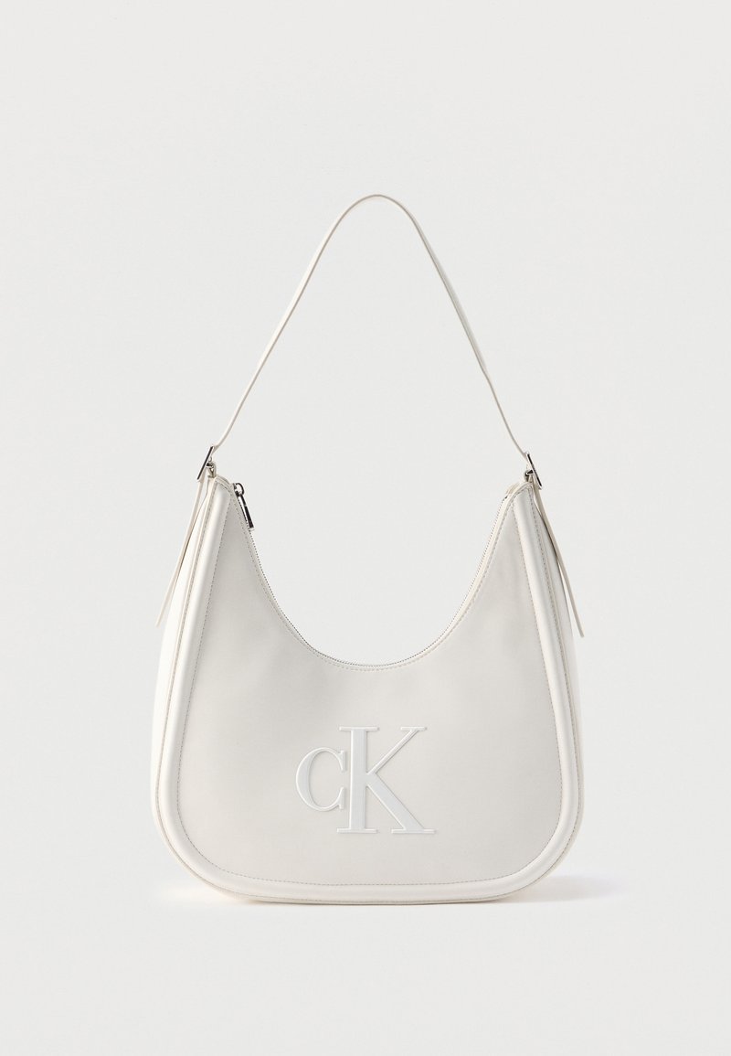 Λευκή δερμάτινη τσάντα ώμου με φερμουάρ, καμπυλωτό σχήμα και ανάγλυφο λογότυπο CK μπροστά.