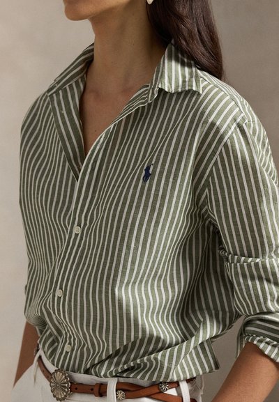 Grün-weiß gestreiftes Hemd zum Knöpfen aus strukturiertem Stoff, mit spitzem Kragen und kleinem Logo auf der Brust.
