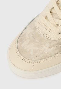 Beige sneakers med en tekstureret overdækning i stof, der har et subtilt logomønster, glatte læderdetaljer og en gummisål. Rund tådesign.