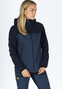 Navy blue, waterproof jacket with a zip closure, adjustable hood, and zippered pockets; features contrasting upper fabric and textured accents.