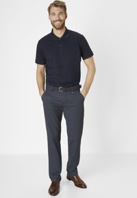 Navy polo shirt, short sleeves, paired with dark grey dress pants and brown leather shoes; features a woven belt, slim fit design.