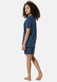 Completo pigiama in cotone blu navy composto da una maglietta a maniche corte con un piccolo motivo di animali e pantaloni corti coordinati. Tessuto morbido e vestibilità comoda.