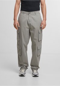 Pantalons cargo gris clair avec plusieurs poches latérales, fabriqués en coton. Coupe décontractée avec une jambe droite et fermeture à bouton.
