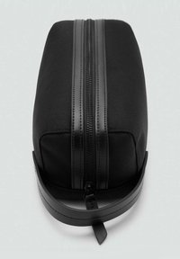 Sac rectangulaire noir en tissu texturé avec une fermeture éclair en cuir lisse et une bandoulière. Doté d'une seule fermeture éclair supérieure et d'un design minimaliste.