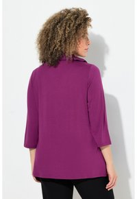 Lila Langarmshirt mit Kragen aus weichem Stoff. Verfügt über Dreiviertelärmel und eine lockere Passform, ideal für legere Anlässe.