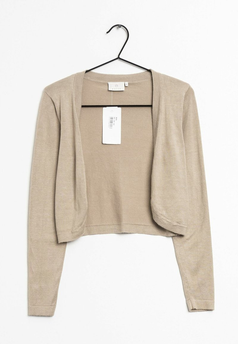 Cardigan beige court à ouverture devant avec manches longues suspendu sur un cintre noir, avec une étiquette blanche de prix attachée à l'encolure.
