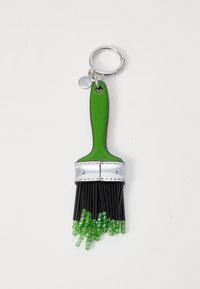 Porte-clé en forme de pinceau vert avec une virole en métal argenté et des poils noirs, agrémenté d'accents de perles vertes imitant des gouttes de peinture.