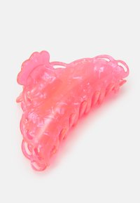 Clips de cabelo em acrílico rosa na forma triangular com bordas onduladas e múltiplos dentes de aderência. Material translúcido com uma textura mármore.