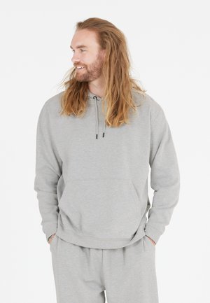 Grijze hoodie met een voorzak, trekkoordsluiting en geribde manchetten, gecombineerd met bijpassende grijze broek in een ontspannen pasvorm.