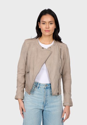 Veste en cuir gris clair au design court, avec une fermeture éclair à l'avant et un col montant, associée à un jean taille haute bleu.