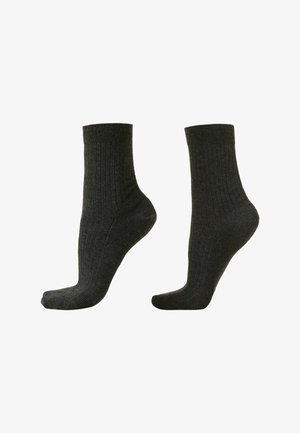 Chaussettes côtelées gris foncé de longueur mi-mollet, fabriquées à partir d'un tissu doux, présentant un design classique avec un renforcement au niveau des orteils et du talon.