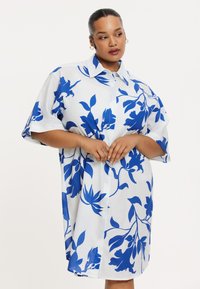 Übergroßes Hemdblusenkleid aus weißer Baumwolle mit blauem Blumendruck, kurzen Ärmeln, klassischem Kragen und lässiger Passform.