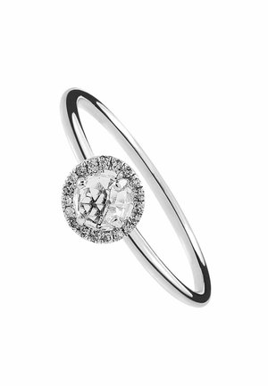 Anillo de plata con una gema central transparente rodeada por un halo de piedras más pequeñas, con una banda suave y pulida.