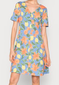 Vestido de manga corta con fondo azul y vibrantes flores naranjas y limones amarillos. Hecho de un tejido ligero con un diseño de escote en V.