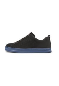 Zwarte suède sneaker met een blauwe rubberen zool, ronde neus, zes gaatjes voor veters en een lus aan de achterkant. Schoon, minimalistisch ontwerp.