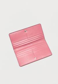 Ροζ δερμάτινο πορτοφόλι με πολλαπλές θήκες για κάρτες, λεία υφή, κούμπωμα με πατιτούρα και ανάγλυφο λογότυπο της μάρκας στο εσωτερικό. Συμπαγής ορθογώνιος σχεδιασμός.