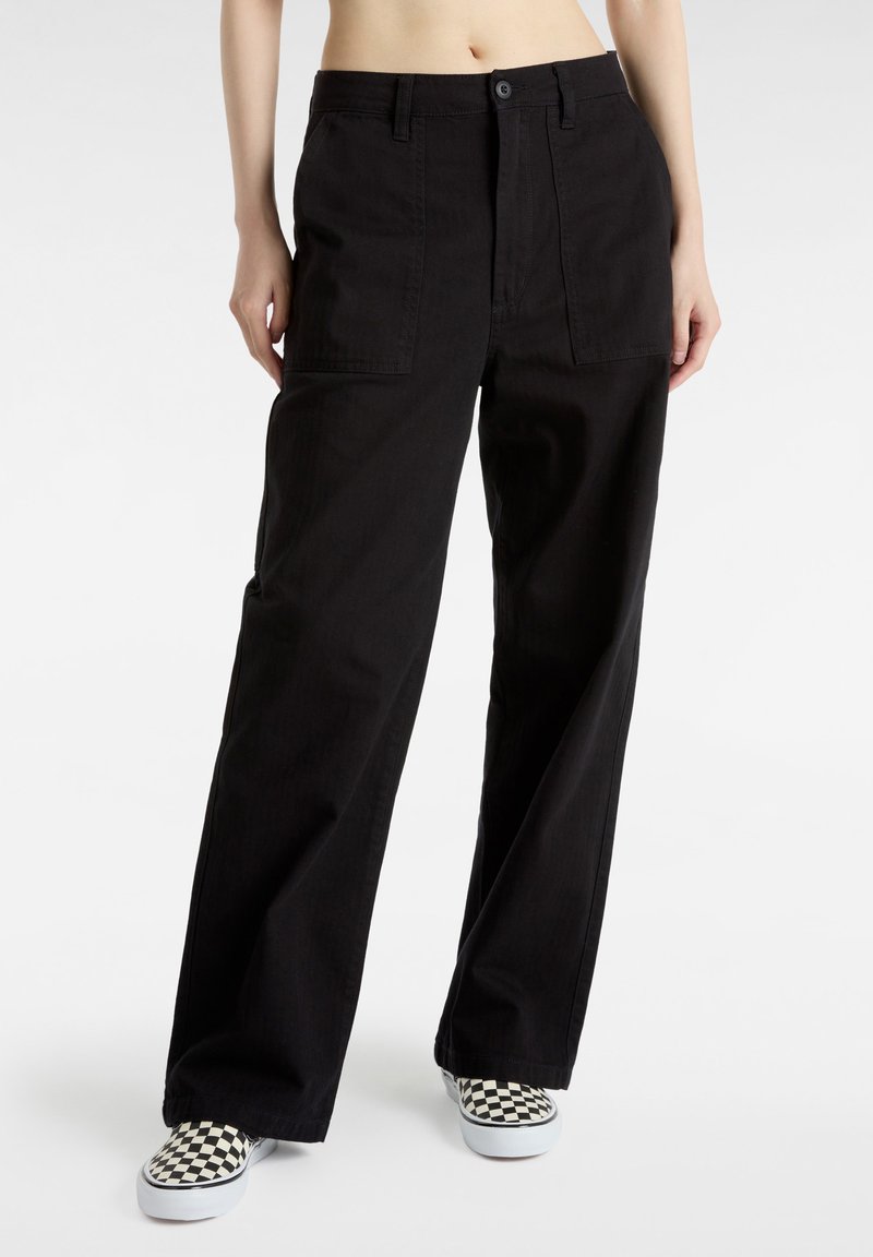Zwarte broek met wijde pijpen, gemaakt van duurzaam materiaal, met een hoge taille, twee voorzakken en gecombineerd met zwart-wit geruite instappers.