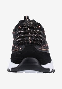 Baskets de sport noires avec un design texturé, accents en or rose, semelle blanche épaisse et languette rembourrée avec des lacets et des œillets noirs.