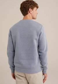 Hanorac albastru deschis, cu un design simplu, guler și manșete cu nervuri. Fabricat dintr-un material moale, texturat, cu o croială lejeră.