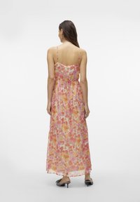 Floral maxi dress with thin straps, featuring a pink and orange pattern, flowing fabric, and a fitted bodice that transitions to a loose skirt.