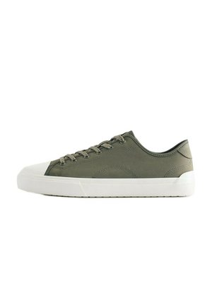 Baskets basses vert olive avec semelle en caoutchouc blanche et bout renforcé, avec lacets assortis et détails de coutures subtils.