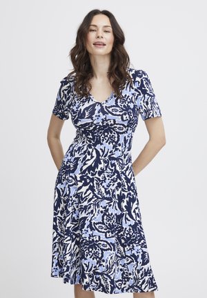 Robe à manches courtes, col en V avec un motif floral en marine, bleu clair et blanc. Fabriquée en tissu doux avec une jupe évasée et des poches latérales.