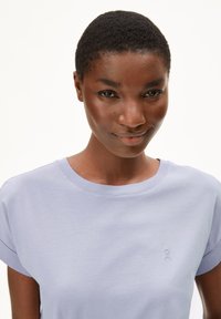 Light lavender short-sleeve t-shirt made of soft cotton. Features a round neckline and a small embroidered logo on the chest.