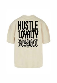 Bež oversize t-särk, millel on julge must tekst: "TÖÖ", "TRUUUSUS" ja "AU" erinevates gooti stiilis fontides, lihtsa disainiga.