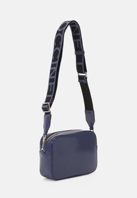 Borsa rettangolare blu navy con finitura lucida, tracolla nera regolabile con logo e dettagli in zip silver.