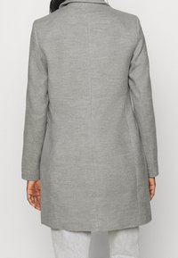 Abrigo gris de mezcla de lana con un diseño entallado, mangas largas y corte recto. Vista trasera muestra una costura sencilla y sin adornos visibles.