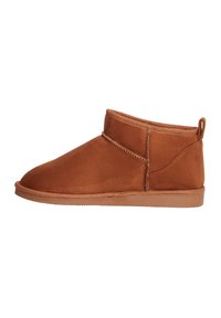 Botas de tobillo de ante marrón con una textura suave, puntera redonda, detalles de costura mínimos y una lengüeta en la parte posterior para facilitar el calzado.