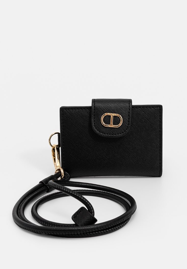 Portacarte in pelle nera texturizzata con chiusura a patta, hardware dorato e tracolla intrecciata rimovibile. Forma rettangolare compatta.