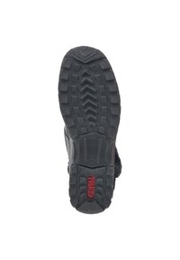 Black footwear outsole with a textured pattern for grip, featuring a red logo and a flexible rubber midsole for comfort and durability.
