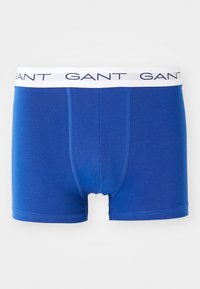 Blue men's boxer briefs with white waistband featuring repeated "GANT" logo in navy blue letters.