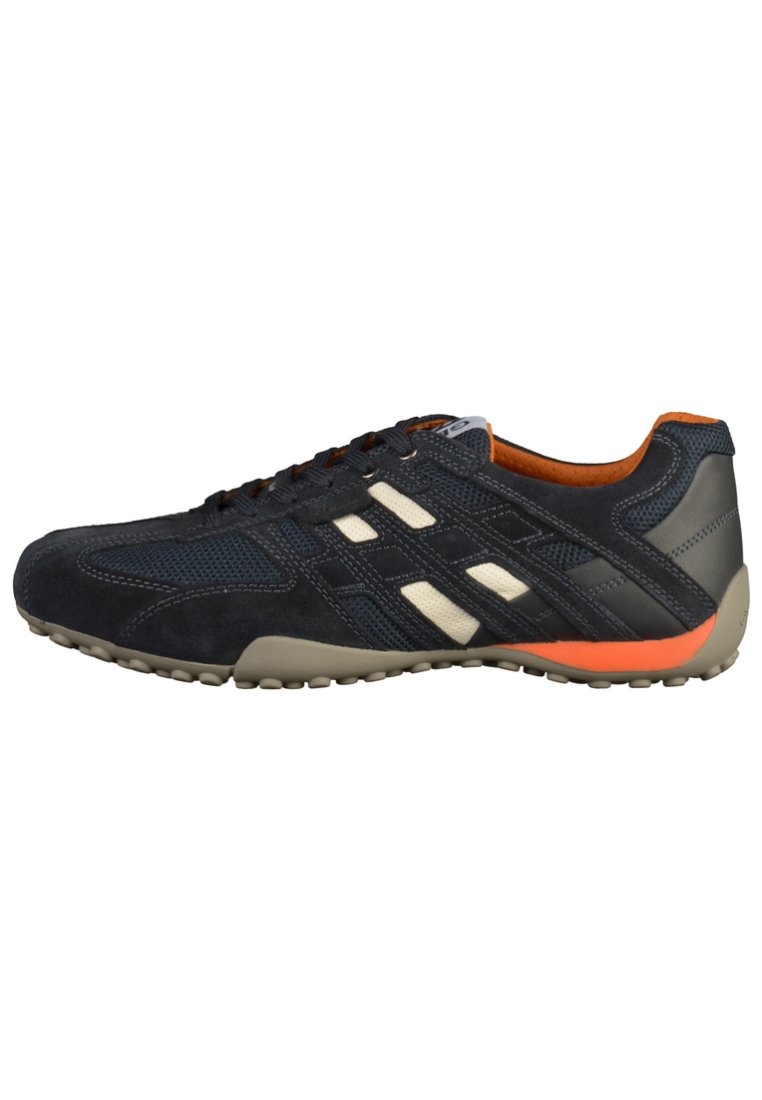 Navy athletic shoe with beige accents, suede and mesh materials, low profile, orange heel detail, and textured rubber sole.