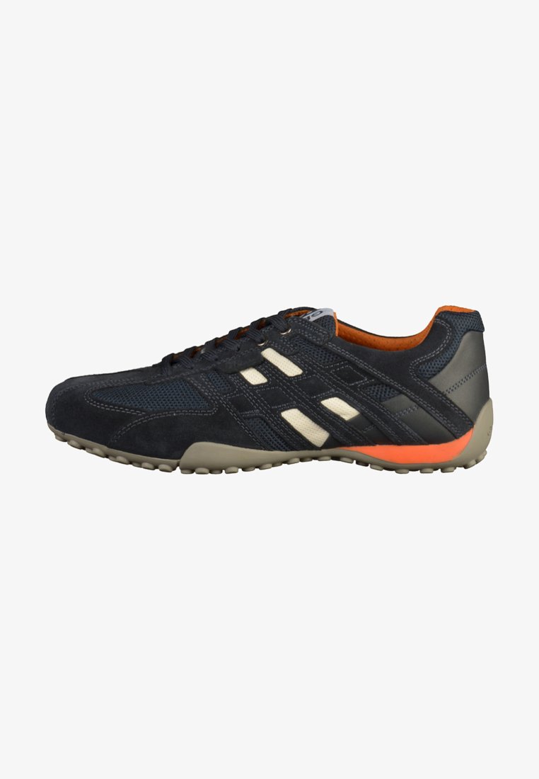 Navy athletic shoe with beige accents, suede and mesh materials, low profile, orange heel detail, and textured rubber sole.