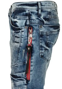 Denim jeans met een vervaagde blauwe wassing, voorzien van een opvallende rode rits en zwarte accenten aan de zijkant, met meerdere zakken en gescheurde details.