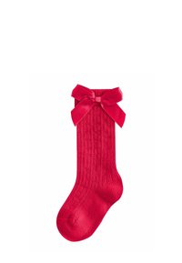 Rote gerippte Socke mit einer großen Satin-Schleife am Bündchen, auf einem weißen Hintergrund präsentiert.
